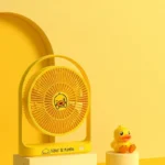 Jisulife FA19B BDuck yellow color portable rechargeable desktop fan with official cartoon character print adjustable tilt head single power control button and Type-C input charging port front view turn on