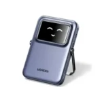 UGREEN 35605B 5000mAh 20W Magnetic Wireless Power Bank Grey showing a space grey pocket-sized portable charger standing with an extended metal kickstand and an animated emoji TFT status screen view like the device in image_644ea2.png