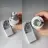 White Smart B22 to B22 IR Lamp Holder adapter showing its metallic male connecting pins cylindrical plastic housing infrared receiver window and small black handheld wireless remote controller button layout