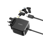 UGREEN X377 35063 67W USB-C PD GaN Universal Power Adapter showing its premium matte black block shape, standard integrated 1.8-meter Type-C cord, three interchangeable yellow and blue laptop barrel tips, and UK 3-pin layout on a clean white background