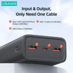 USAMS-AT 65W 30000mAh premium high capacity heavy duty laptop portable fast charging power bank kit from Yattu Series in dark gray showing sleek two-tone textured armor housing body layout glossy front mirror display tracking battery percentages and dual standalone heavy duty 100W type-c to type-c charging cables side view]