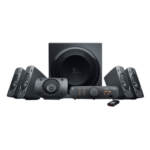 Logitech Z906 5.1 surround sound theater speaker system displaying its four angled satellite speakers, horizontal center channel unit, large side firing wooden subwoofer box, sleek desktop control console module, and slim wireless remote lines